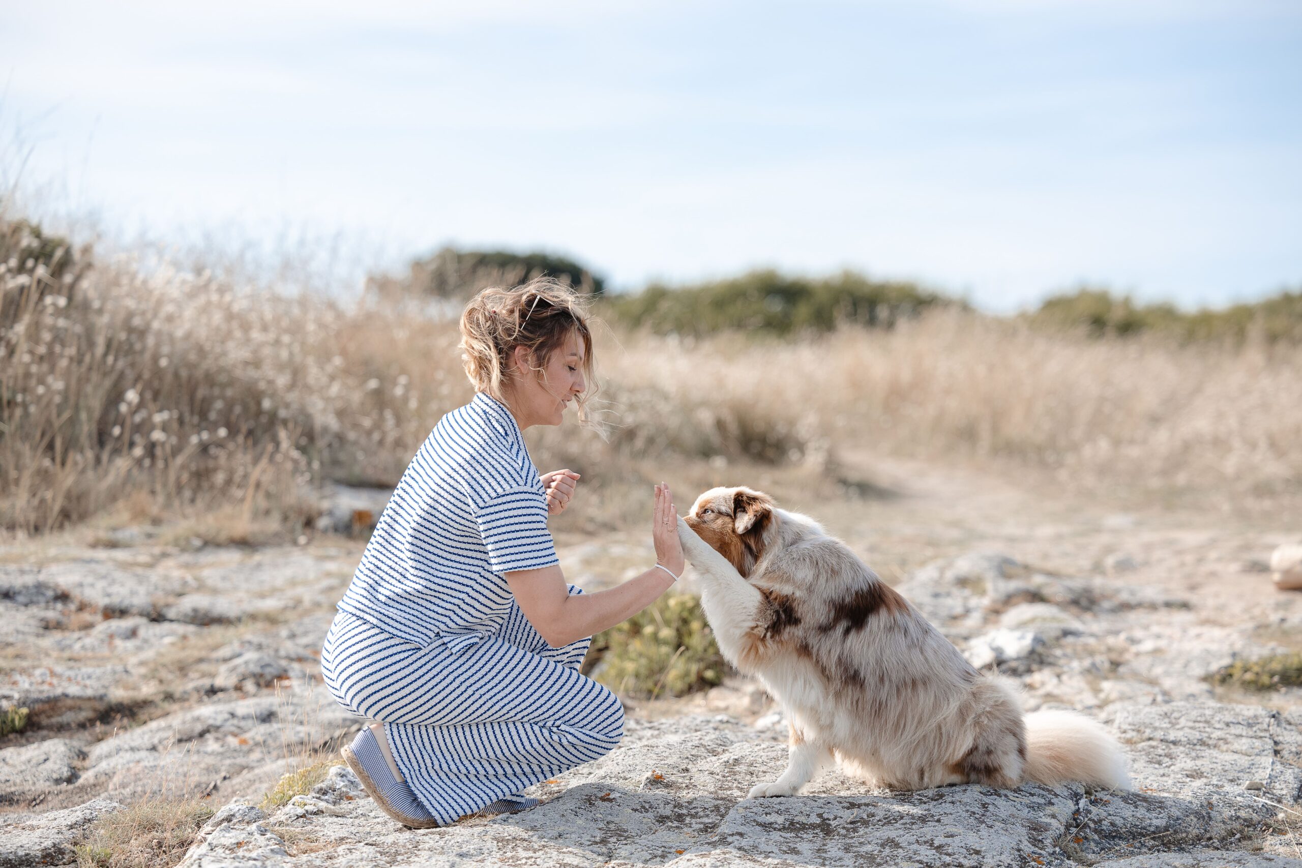 Femme étreignant son chien sur la plage lors d’une séance photo famille à Saint-Malo