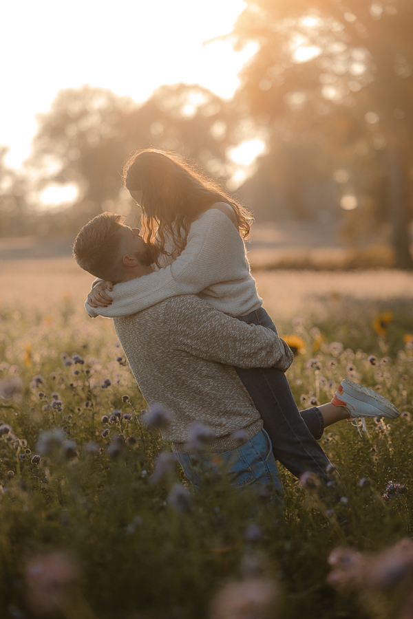 Séance engagement à Liffré au coucher du soleil dans un champ de fleurs
