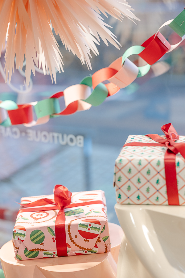 Paquets cadeaux aux motifs festifs et guirlande colorée en vitrine de la boutique Clebs à Rennes, décorée pour les fêtes