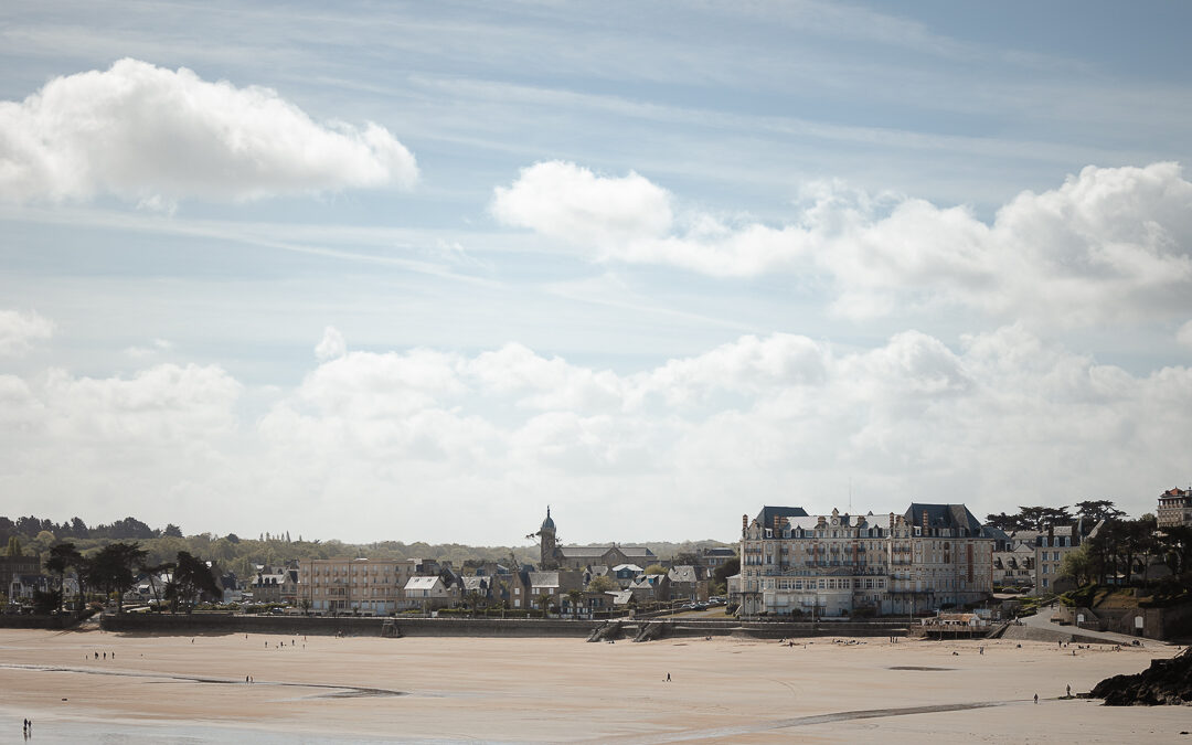 Vue panoramique sur la baie de Saint-Lunaire et la pointe du Décollé. Les villas historiques se dessinent sur l'horizon breton sous une lumière douce de fin de journée.